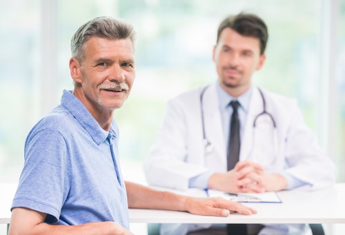 Smiling male patient sitting at doctors office and looking at camera